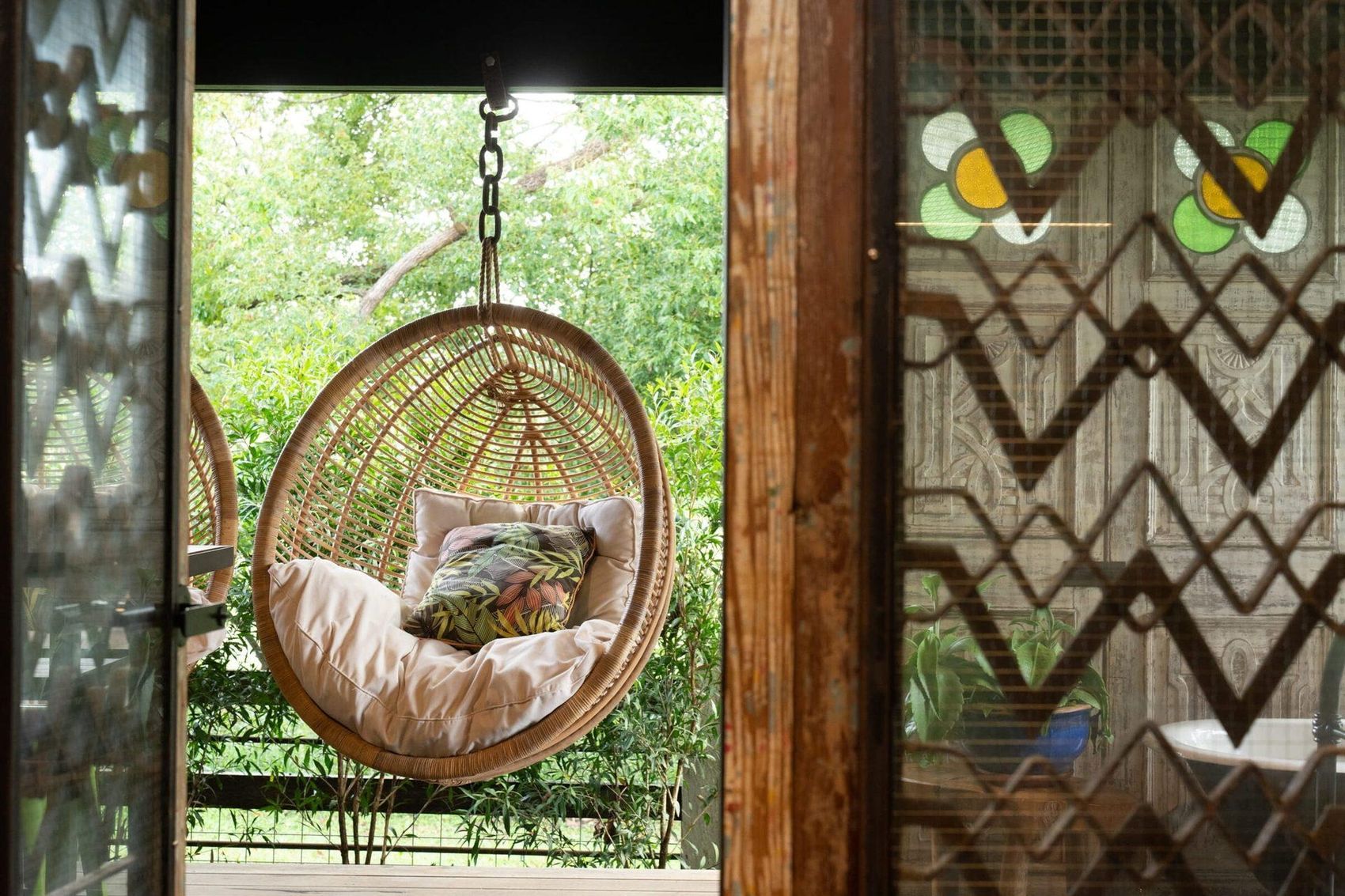 a hanging chair framed by stained glass