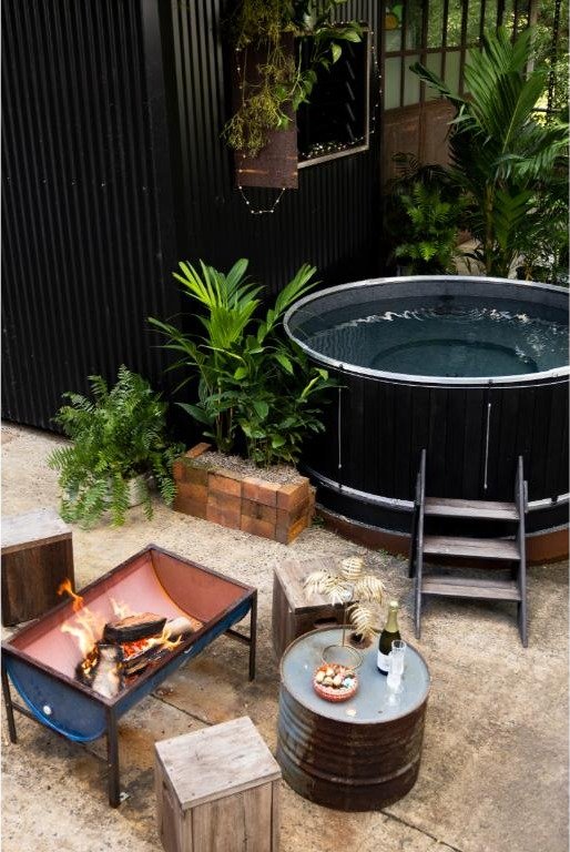 The heated magnesium plunge pool beside a fire pit, set in tropical greenery